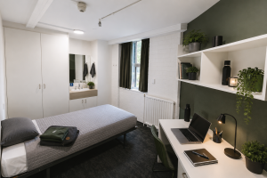 Mannix Bedroom Sample (5) Refurbished corner student bedroom featuring a single bed, study desk, built-in wardrobe, sink, heater and high-speed Wi-Fi.